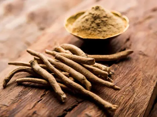 Ashwagandha-Wurzeln und Pulver auf Holz. Die Frage "wie schnell wirkt Ashwagandha" beschäftigt viele, die auf natürliche Unterstützung setzen.