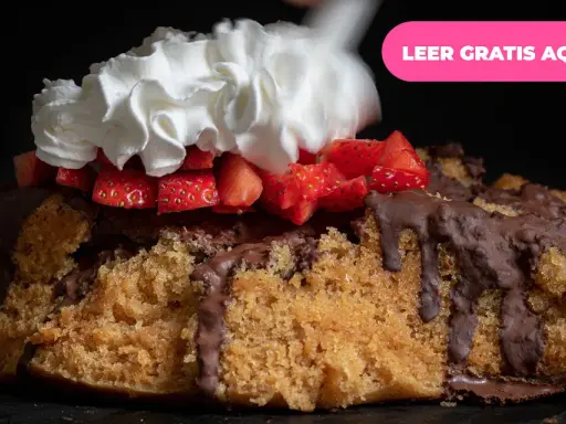 Pastel de bizcocho con chocolate derretido, fresas y una generosa porción de nata montada.