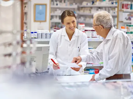 Farmaceutka wyjaśnia seniorowi, od kiedy dostępne są darmowe leki dla seniorów.