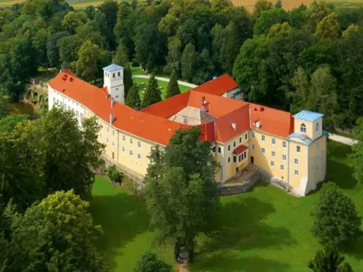 Malowniczy hotel zamek otoczony zielenią.