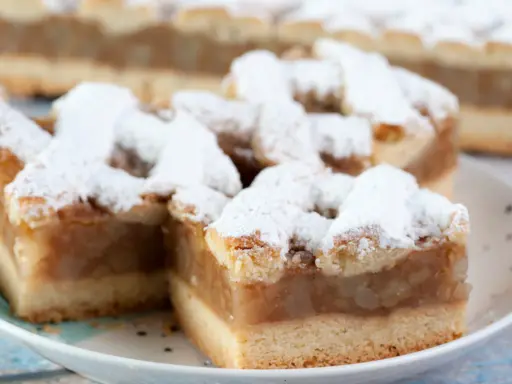 Kawałki pysznej, domowej szarlotki z kratką z ciasta, posypane cukrem pudrem. Babcina szarlotka najlepsza!