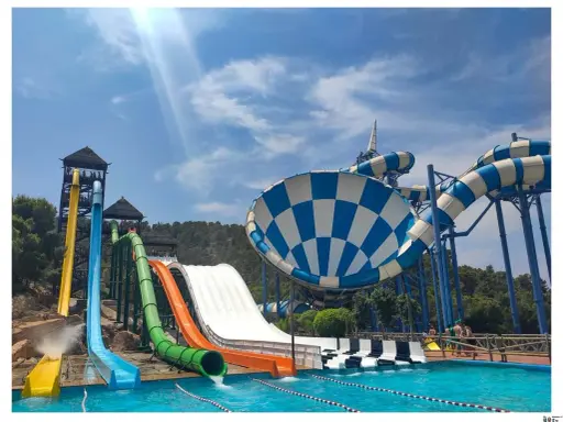 Toboganes acuáticos de colores vibrantes y una piscina azul cristalina, ideal para saber qué hacer en Benidorm con niños y disfrutar de un día refrescante.