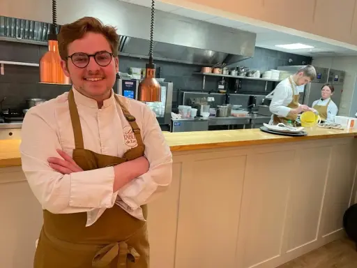 Le chef souriant du restaurant Le Mans, avec son équipe en cuisine.