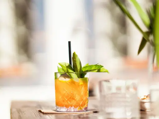 Erfrischender Cocktail mit Irish Whiskey, Zitrone und Basilikum, perfekt für warme Tage.