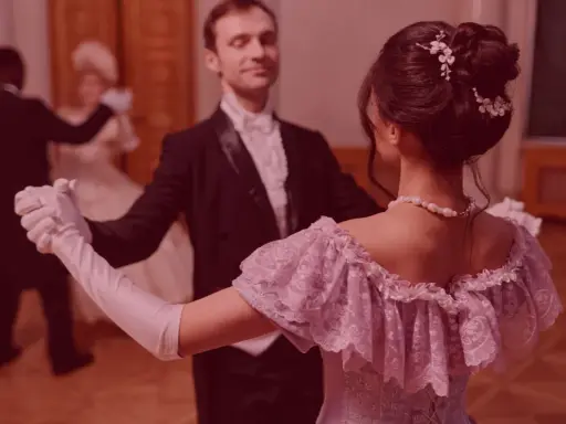 Elegancka para tańczy powolny walc na balu. Ona w pastelowej sukni, on w fraku.