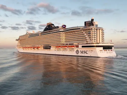 La MSC Seascape, imponente nella sua lunghezza, solca le acque calme al tramonto, riflettendosi sul mare.