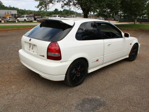 Białe Honda Civic EK9 Type R z czarnymi felgami i spojlerem, gotowe do jazdy.