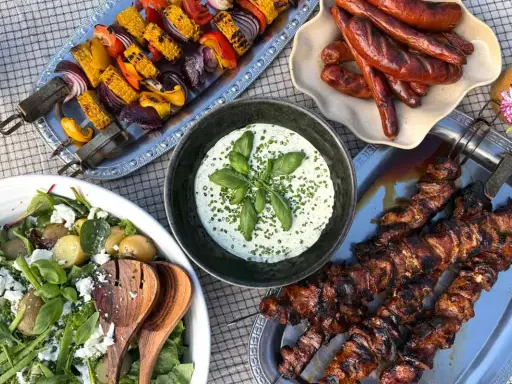 Grillad skinkstek i gryta, korv, grönsaksspett och en fräsch potatissallad med fetaost. En perfekt sommarmåltid!