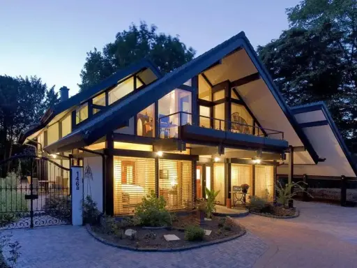 Maison moderne avec grandes fenêtres, balcons et jardin. Le prix d'une maison autonome comme celle-ci peut varier.