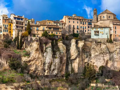 Häuser klammern sich an steile Felsen in Cuenca, Spanien. Eine Kathedrale thront über der Stadt.