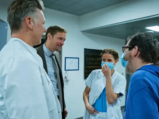 Tuva Novotny och Alexander Skarsgård i samtal med sjukhuspersonal.