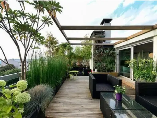 Un accogliente terrazzo rustico con mobili neri, un giardino verticale e piante rigogliose, ideale per rilassarsi.