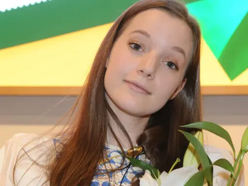 Sanah z bukietem białych lilii, uśmiechnięta, jakby przeżywała najlepszy dzień w moim życiu.