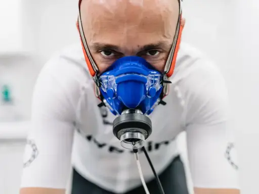 Mężczyzna w masce do testów wydolnościowych, badanie VO2 max. Intensywny wysiłek w celu poprawy kondycji.