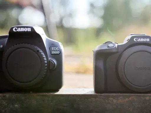 Dwa aparaty Canon EOS 2000D stoją obok siebie. Wady i zalety tego modelu są kluczowe dla początkujących fotografów.