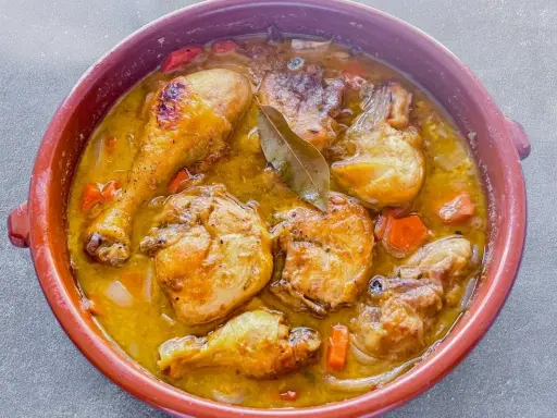 Muslos de pollo en salsa, un plato casero que evoca la receta de la abuela. Jugosos trozos de pollo dorados en una rica salsa con zanahorias y laurel.