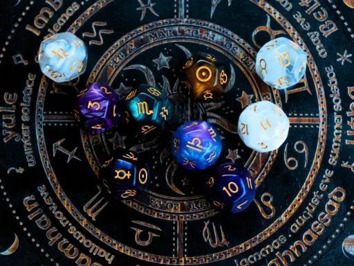 Kolorowe kości do gry na tle zodiaku. Czy to zapowiedź horoskopu tygodniowego dla Wagi?