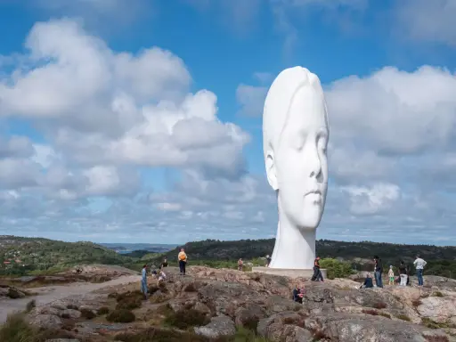 Enormt vitt ansikte reser sig mot en molnig himmel. En av de mest minnesvärda platserna att besöka i Göteborg.