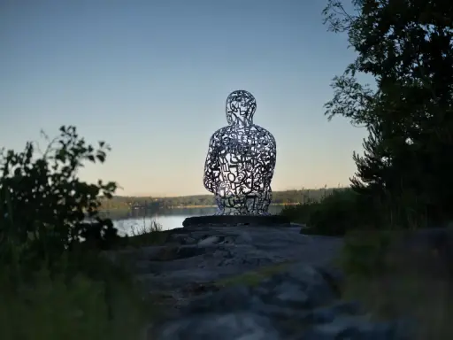 Skulptur av bokstäver vid Artipelag Stockholm, med en sjö i bakgrunden.