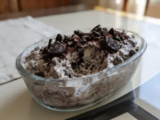Pyszne lody oreo w szklanej misie, posypane pokruszonymi ciastkami i kakao. Idealne na deser!
