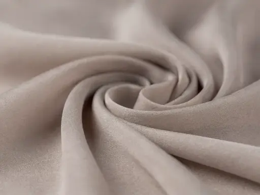 A swirl of soft, beige fabric. This close-up shows the texture and drape of a material, making one wonder, is viscose a good material for flowy garments?