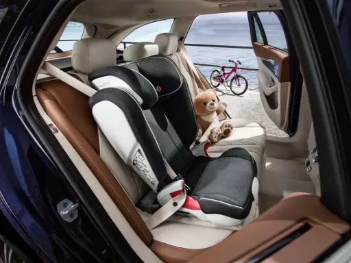Czy fotelik z isofix można zamontować pasami? Tak, ten fotelik jest zamontowany pasem samochodowym, obok siedzi pluszowy miś.