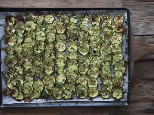 En plåt med ugnsbakad zucchini, skivad och kryddad med örter. Perfekt som tillbehör till middagen.