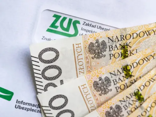 ZUS i polskie banknoty 200 zł. Dokumenty ZUS i pieniądze mogą oznaczać przyszłą okresową emeryturę kapitałową.