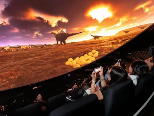 Besökare njuter av en dinosaurieupplevelse i en kupolformad salong, som en del av universum i Göteborg.