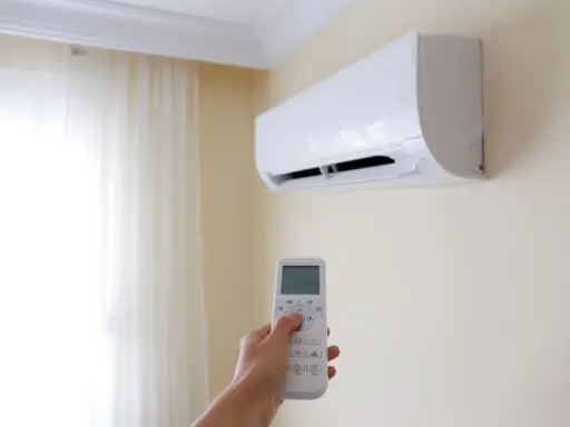 Mano che regola il climatizzatore per un ambiente fresco e dry.