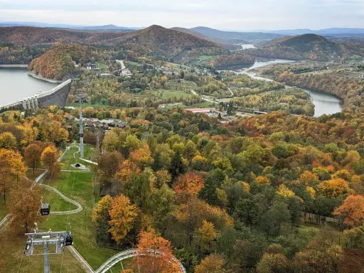 Jesienna panorama z widokiem na zaporę w Solinie i kolejkę gondolową. W oddali jezioro i góry.
