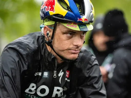 Anton Palzer im Regen, mit Red Bull Helm und BORA-Hansgrohe Jacke.