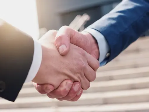 Umorzenie postępowania egzekucyjnego zakończone uściskiem dłoni. Dwie osoby w garniturach potwierdzają porozumienie.