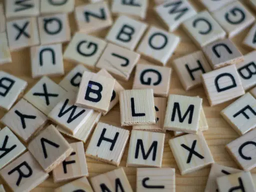 Drewniane klocki z literami, jak w grze Scrabble. Układają się w słowa, może nawet w najdłuższe słowo po angielsku?