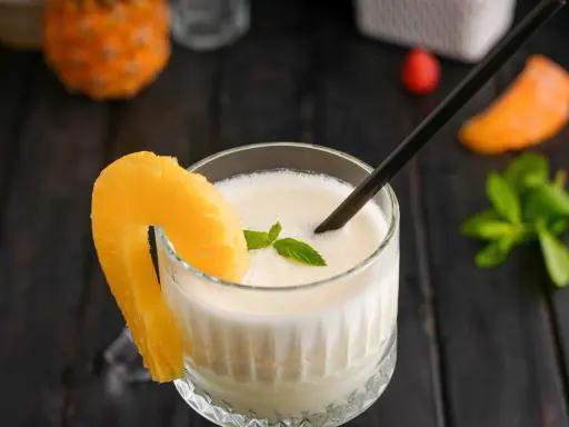 En krämig pina colada med ananasskiva och mynta, redo att avnjutas.