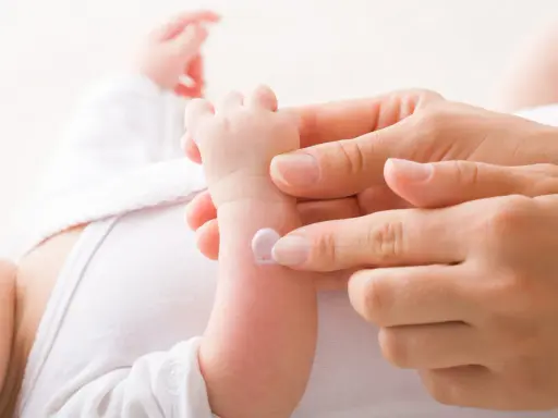 Application de cicalfate nourrisson sur le bras d'un bébé par une main douce.