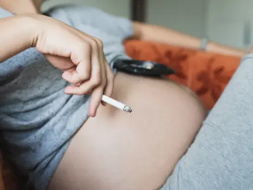 Schwangere Frau hält Zigarette. Hilfe beim Rauchstopp: Cytisin rezeptfrei.