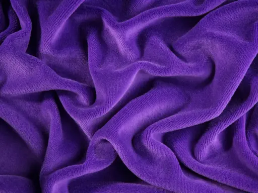 Tessuto di velluto viola drappeggiato, morbido e lussuoso. Scopri come lavare il velluto per mantenerlo splendente.