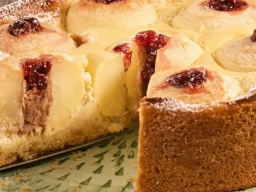 Saftiger Bratapfelkuchen mit Marzipan, verziert mit Marmelade und Puderzucker. Ein Genuss für jeden Anlass.