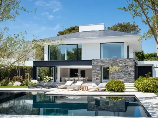 Une maison moderne simple avec piscine, terrasse et mobilier de jardin. Le soleil brille sur cette demeure épurée.