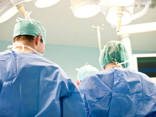 Chirurdzy w zielonych czepkach i niebieskich fartuchach przygotowują się do klasycznej operacji prostaty.