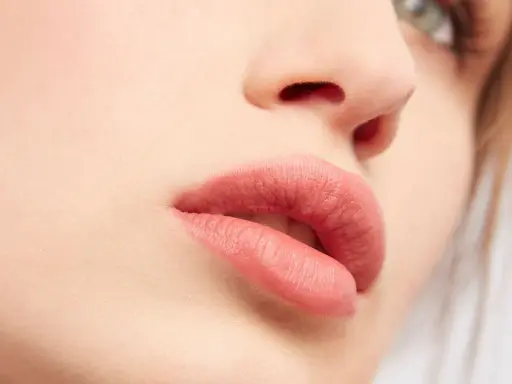 Labbra sensuali con rossetto color carne, un look naturale che esalta la bellezza di ogni donna.