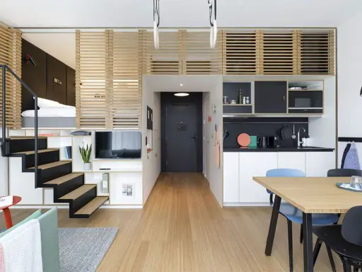Idée aménagement petit appartement : lit en mezzanine, escalier, cuisine, salle à manger et salon dans un espace optimisé.
