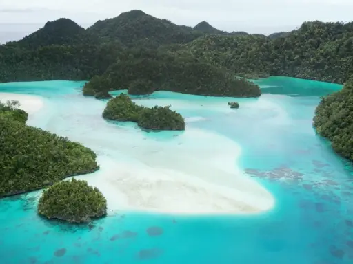 Rajskie krajobrazy Raja Ampat: turkusowe laguny, piaszczyste ławice i bujna zieleń tropikalnych wysp.