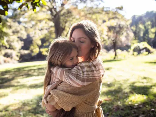 Mutter küsst ihr Kind zärtlich im Arm. Ein Moment voller Liebe, der die Essenz von gentle parenting deutsch widerspiegelt.