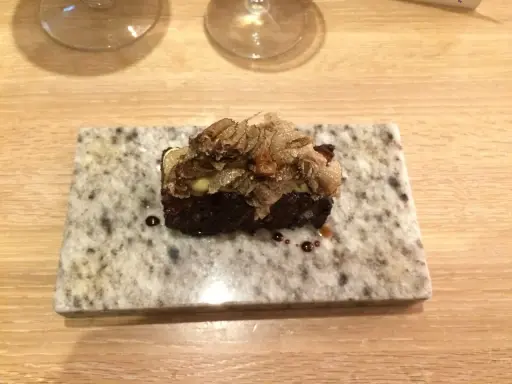 En utsökt liten bit från Marie Laveau meny, toppad med tunna skivor av tryffel.