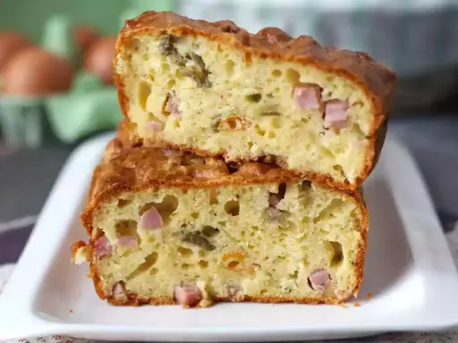 Tranche de cake jambon olive, moelleux et doré, garni de dés de jambon et d'olives vertes. Parfait pour un apéritif gourmand.