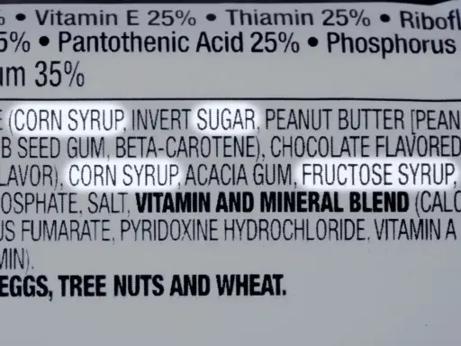 Zutatenliste mit Fruktosesirup, wichtig für Menschen mit Fruktoseintoleranz. Enthält auch Erdnüsse, Nüsse und Weizen.