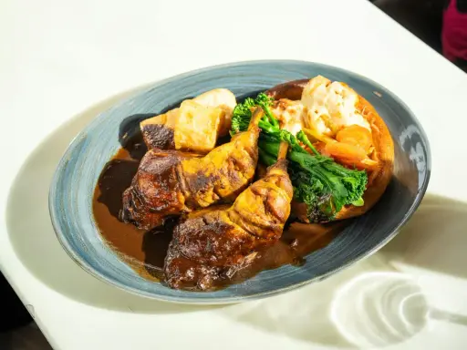 Pyszny niedzielny obiad: pieczone udka kurczaka w sosie, pieczone ziemniaki, brokuły i kalafior zapiekany w Yorkshire pudding.
