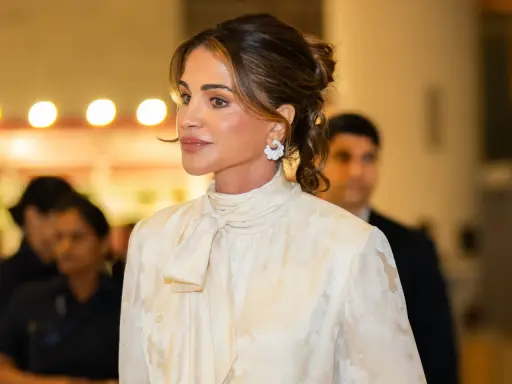 Queen Rania's elegant style shines in a cream, floral-patterned blouse with a chic pussy-bow.